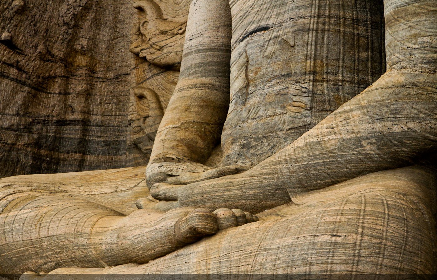 Detail of a reclining stone Buddha carved from the rock face